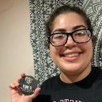 Raneen Allos holding a First Generation Oakland University button.